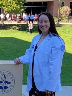 Medical student Danielle Sychowski in a white coat for a profile photo.