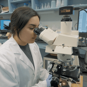 Daniela Alcazar looks into a microscope.