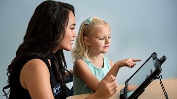 Woman and child working on a tablet to improve the child's speech 