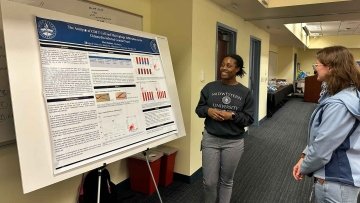 Veterinary Medicine student presents her poster presentation to another student