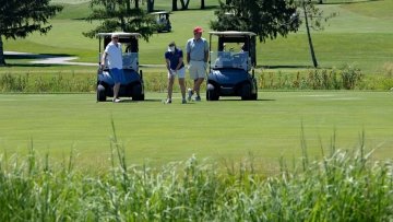 Attendees play golf and drive the golf carts