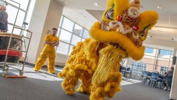 Lion dancers dressed to mark the Year of the Dragon dance in The Commons.