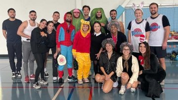 Pickleball tournament players gather for a photo, some with Halloween costumes.