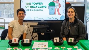 Members of the One Health Club display information about proper recycling methods with a PowerPoint presentation, photos of items, and small bins for attendees to guess where the items should be recycled. 