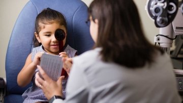 Young child going through eye exam with a doctor.