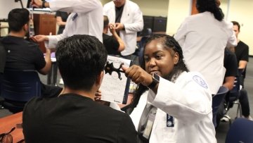 Optometry students perform vision tests on dental students. 