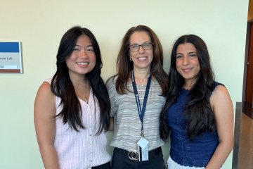 Student Lauren Aniceto, Faculty Cindy Krizizke, and Student Saya Albonaimi stand in a row. 