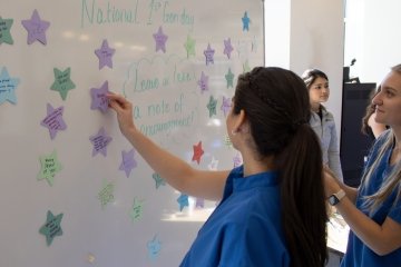 Students add stars to the whiteboard with notes of encouragement.