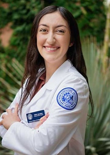 Student in white coat posing for headshot