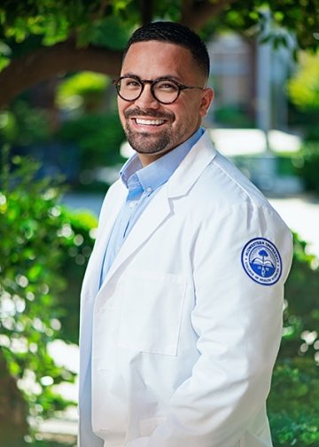 Student in white coat posing for picture.