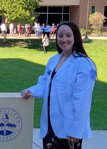 Medical student Danielle Sychowski in a white coat for a profile photo.