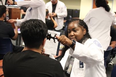 Optometry students perform vision tests on dental students. 