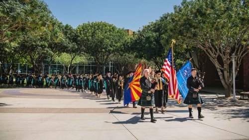 Two bagpipe players lead graduates to their graduation ceremony