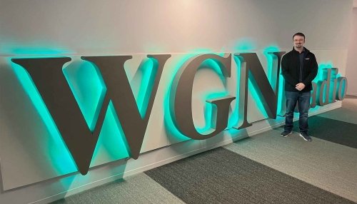 Student stands in front of WGN sign