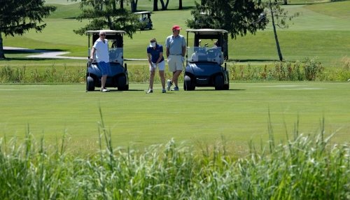 Attendees play golf and drive the golf carts