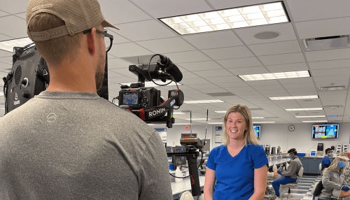 Katie Trimble poses in front of cameraman in the dental lab at Midwestern University.