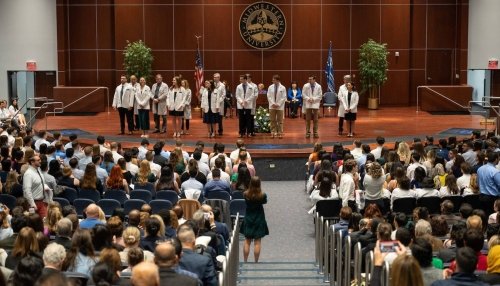 Students receive their white coats.