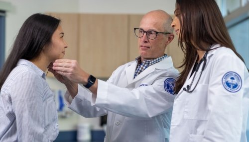 Student and professor examining patients head