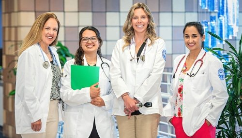 Four nursing faculty members in white coats