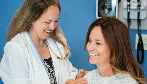 Nurse performing a checkup on a smiling patient