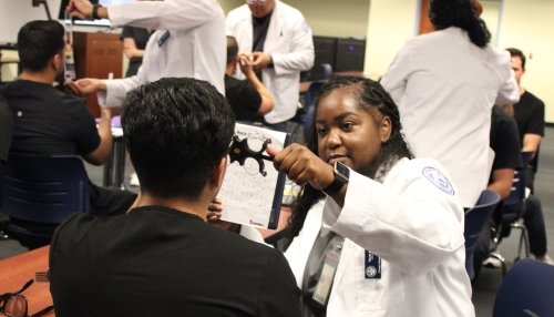 Optometry students perform vision tests on dental students. 