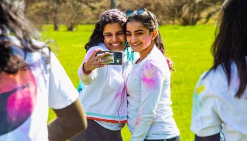 Two girls take a selfie at the Holi Festival.