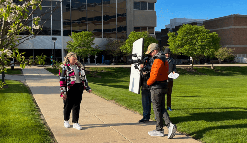 video crew interviewing student outside