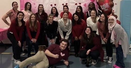 Group of 18 smiling clinical psychology students at a Valentine’s Dance.