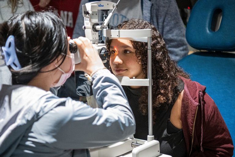High school students learn about optometry equipment.