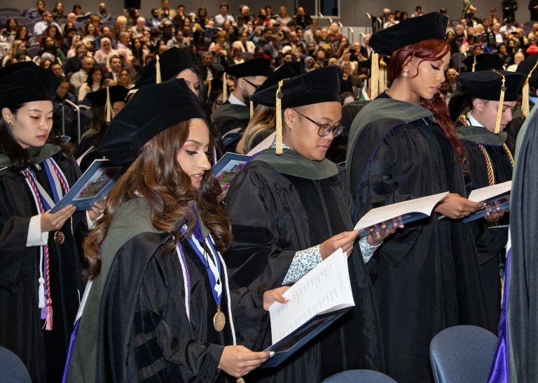 Pharmacy graduates examine their programs. 