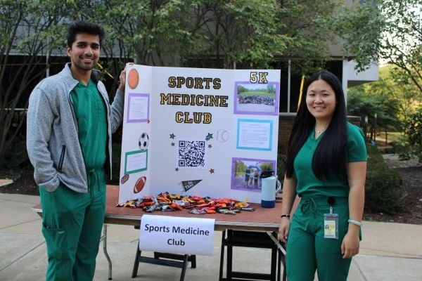 Members of the Sports Medicine Club at the Student Involvement Fair in front of their informational poster.