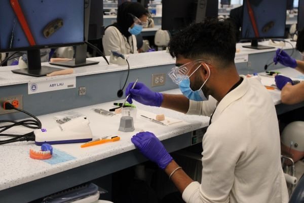 Attendees of the ASDA Pre-dental day in the dental simulation lab performing an activity.