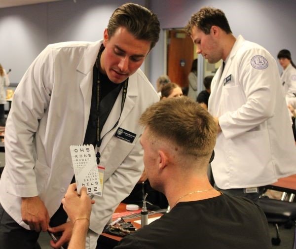 Optometry students perform vision tests on dental students. 