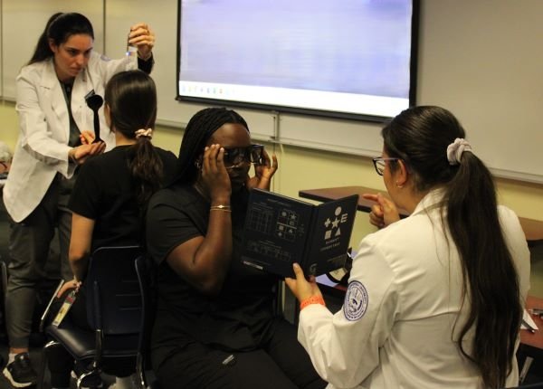 Optometry students perform vision tests on dental students. 