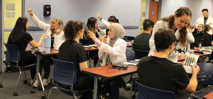 Optometry students perform vision tests on dental students. 